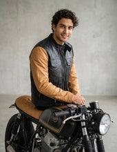 Man sitting on a motorcycle wearing a leather cafe-racer jacket