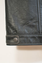 Metal logo hardware and double-stitched hem on men’s black leather biker vest.