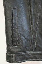 Hand pocket and vertical stitching details on black leather biker vest.