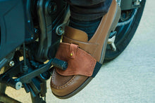 A close-up motorcycle shifter brown leather boot protecotr