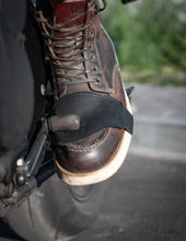 Close-up of black leather motorcycle shifter protector on boot