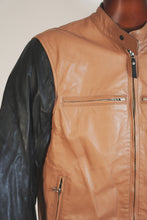 Front close-up of tan and black leather motorcycle jacket with zipper details