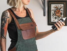 Apron handmade from green canvas and brown leather pockets