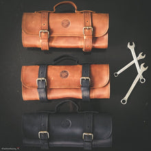 Collection of handcrafted leather motorcycle tool rolls in black and brown with carry handles and buckle closures, offering durable storage solutions for motorcycle repair tools and travel gear.